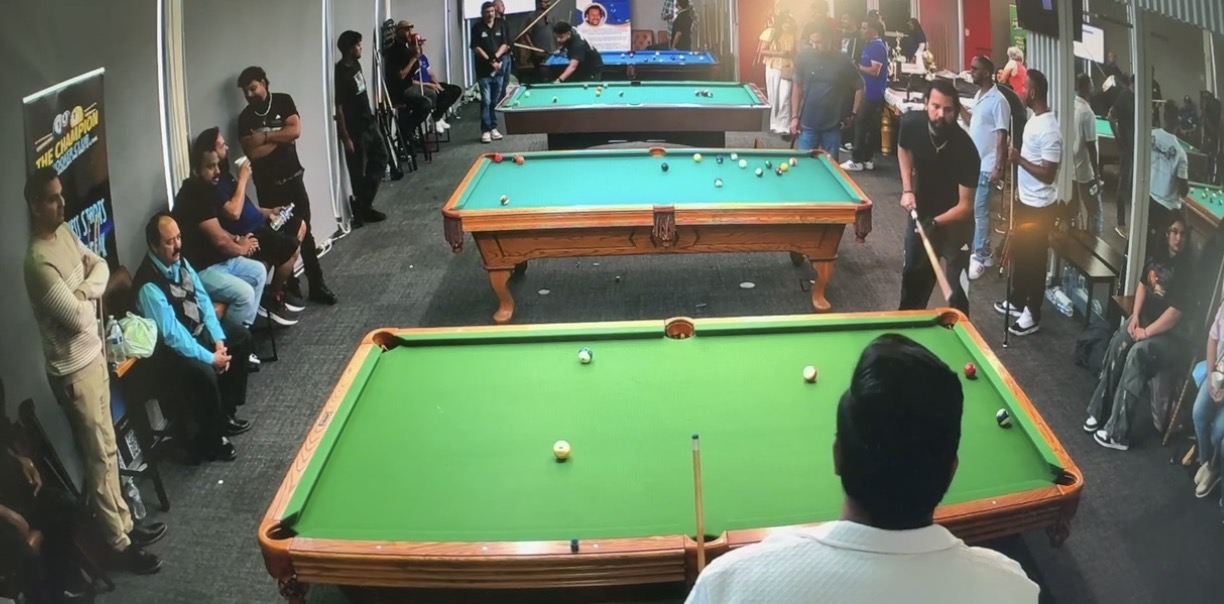 Players and supporters gathered around pool tables